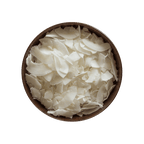 Brown bowl filled with white coconut chips on a black background