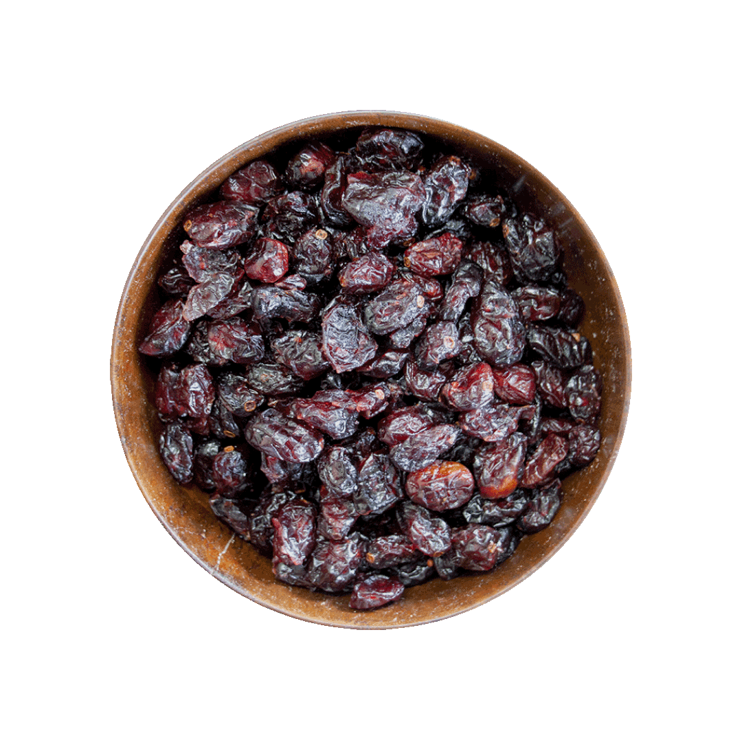 Wooden bowl filled with dried cranberries on a black background